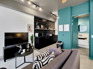 a living room with a couch and a tv at Brand new, luxury, wifi, pool with 24hr security in Cape Town