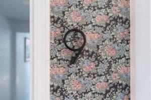 a mirror hanging on a wall with a floral wallpaper at The Cowboy Social Unit 9 in Williams
