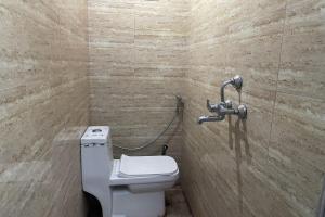 a bathroom with a toilet and a shower at Hotel O Greenwood in Rishop