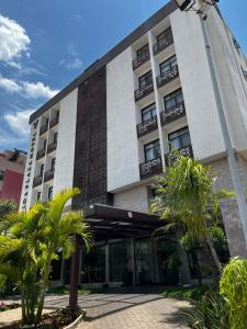 Un edificio con palmeras delante. en Vida Plaza Hotel, en Brasilia