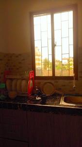 a kitchen counter with a sink and a window at Ekebute BnB in Mombasa