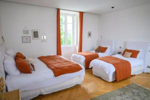 Un dormitorio con dos camas con sábanas naranjas. en Château Toulouse-Lautrec, en Saint-André-du-Bois