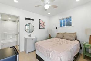 a bedroom with a bed and a bathroom with a ceiling fan at The Cowboy Social Unit 12 in Williams