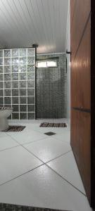 a bathroom with a shower and a tile floor at Casa com garagem no coração de Arraial! in Arraial do Cabo +17 photos