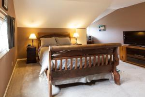 a bedroom with a bed and a flat screen tv at Daisy's Place 30 day minimum in Hood River