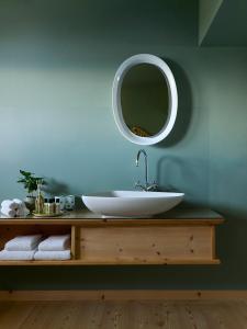 une salle de bain avec un lavabo blanc et un miroir dans l'établissement Berghoferin Fine Hotel & Hideaway, à Redagno 37 autres photos