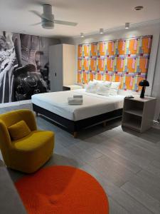 a bedroom with a large bed and a yellow chair at The Cove By Renzzi in Miami Beach