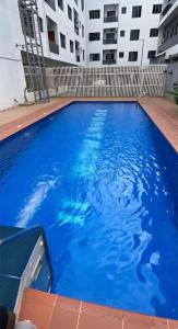 a large blue swimming pool in front of a building at Oasis in the Heart of Lekki Phase I in Moba +23 photos