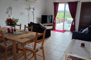 a living room with a wooden table and chairs at 2-Bed House Sleeps 6 -Pool -Free Parking -Netflix in Mandria