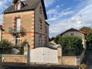 ein Haus mit einem weißen Zaun davor in der Unterkunft La Maison d'Elise in Usson-du-Poitou