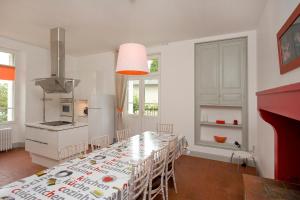 eine Küche mit einem langen Tisch und Stühlen in einem Zimmer in der Unterkunft La Maison d'Elise in Usson-du-Poitou