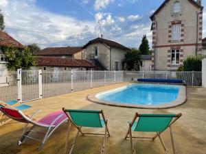 2 Stühle und ein Pool im Hof in der Unterkunft La Maison d'Elise in Usson-du-Poitou