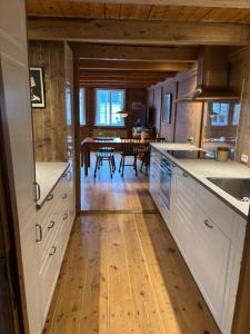 a kitchen with white cabinets and a wooden floor at Beautifully restored traditional home in old town Tórshavn in Tórshavn +7 photos