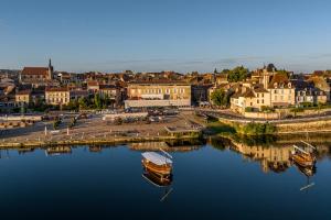 Un barco está atracado en el agua junto a un pueblo. en Ele STUDIO indépendant, en Bergerac