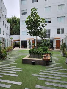 a courtyard with a tree and benches in front of a building at Departamento Osma in Lima