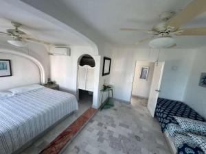 Un dormitorio con una cama y un ventilador de techo. en Manzanillo Beautiful Views Private Pool, en Manzanillo 23 fotos más