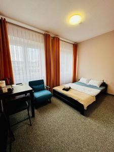 a bedroom with a bed and a desk and a chair at Hotelino Stare Miasto Częstochowa in Częstochowa