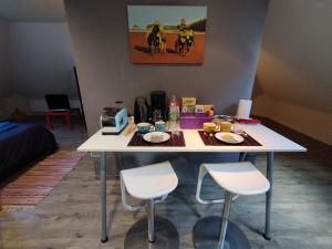 una mesa blanca con dos sillas y comida en ella en Vaste chambre à Vouvray, en Vouvray 9 fotos más