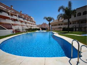 a large swimming pool in front of a building at Duplex penthouse with 4 bedrooms and stunning sea views in Benalmádena