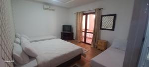 a bedroom with a bed and a tv and a window at Tamriluxe in Tamri