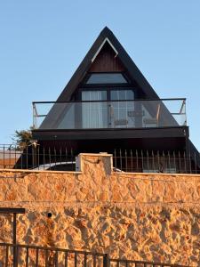 a house on top of a stone wall at Umm Aljulud Cottages in Ajloun