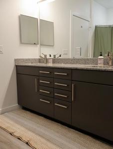 Un baño con lavabo y un espejo grande. en Townhome in North Austin, en Austin