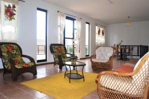 a living room with chairs and a table and windows at Brisa Do Vale Pousada in Itaobim