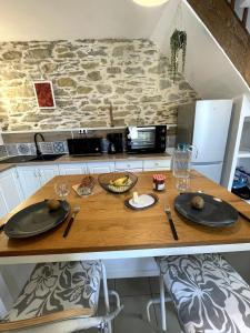 a kitchen with a wooden table with plates and utensils at Charming house with terrace in Laval