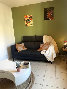 a living room with a couch and a table at Charming house with terrace in Laval