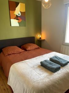 a bedroom with a bed with two towels on it at Charming house with terrace in Laval +39 photos