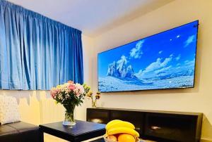 a living room with a flat screen tv on the wall at Central Apartment with 75inch TV Netflix in Andover +10 photos