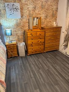 a bedroom with a dresser with a mirror on it at Cosy single, double and king size rooms with shared bathroom in Manchester