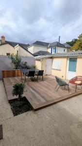a wooden deck with a table and chairs on it at Charming house with terrace in Laval