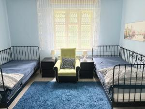 a bedroom with two beds and a chair and a window at Chatki Zielarki in Wisła