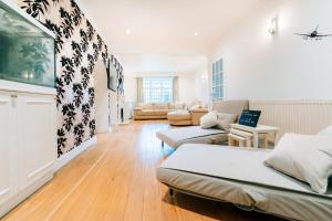 a living room with two beds and a couch at Bright & Comfy 3-BR House in Feltham - Sleeps 7! in New Bedfont