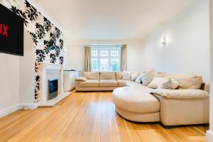 a living room with two couches and a fireplace at Bright & Comfy 3-BR House in Feltham - Sleeps 7! in New Bedfont