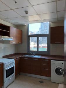 アブダビにあるPerfecto Studio Apartmentsのシンクと窓のあるキッチン