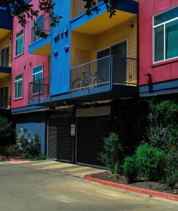 Una hilera de coloridos edificios de apartamentos con un estacionamiento. en Townhome in North Austin, en Austin