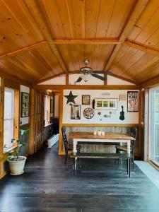 a living room with a wooden ceiling and a bench at Cacapon Riverside Getaway in Great Cacapon