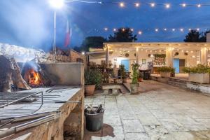 a fire pit in a patio at night at Masseria Dipinto di Blù in Felline