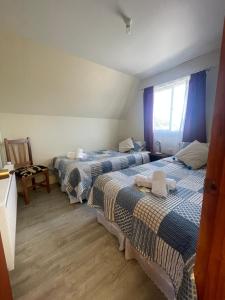 a room with two beds and a window at CabañasRioBlanco in Chaitén +3 photos