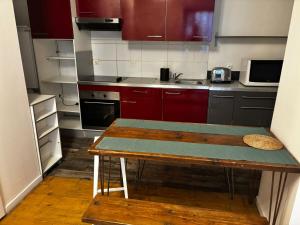ボルドーにあるBourse du travail - Bordeaux centreのキッチン(赤いキャビネット、木製テーブル付)