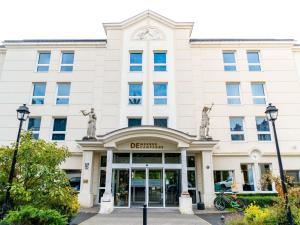 ein Gebäude mit einer Uhr darüber in der Unterkunft Hotel Mercure Château de Fontainebleau in Fontainebleau