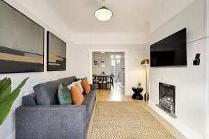 Una sala de estar con un sofá y una chimenea. en Balfour House - Air Host & Stay - Sleeps 8, free parking, en Litherland