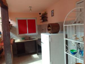 a kitchen with a white refrigerator and red cabinets at Laura in Santa Rosa de Calamuchita
