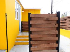 una puerta de madera frente a un edificio amarillo en Villas at Auxilio Mutuo 106, en San Juan
