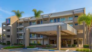 een hotelgebouw met palmbomen ervoor bij Motel 6-Anaheim, CA - Maingate in Anaheim