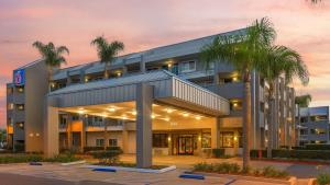 Un edificio con palmeras delante. en Motel 6-Anaheim, CA - Maingate, en Anaheim