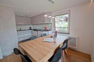 a kitchen with a wooden dining table and chairs at Bishorn, Chalet Wiedersehn in Grächen
