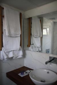 een badkamer met een wastafel en een spiegel met handdoeken bij Port Marina Hotel in Karatas
